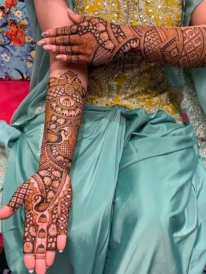 A different angle of the peacock-themed design, showing how the patterns flow from the hands up the arms.