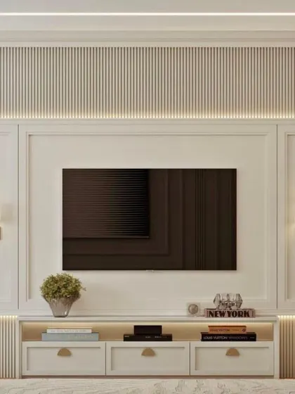For a touch of classic elegance, this TV unit features intricate molding, symmetrical wall sconces, and a clean white finish. The design provides ample storage while maintaining a refined look.