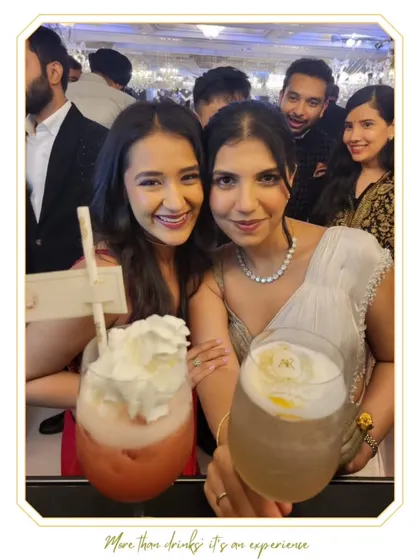 Two guests cheers with their frothy, whipped-cream-topped cocktails. These fun and indulgent drinks are always a crowd-pleaser.