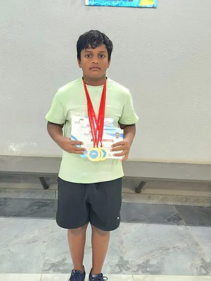 Nayan Prabhas shows off his three gold medals in freestyle, backstroke, and breaststroke, showcasing his versatility as a young swimmer.