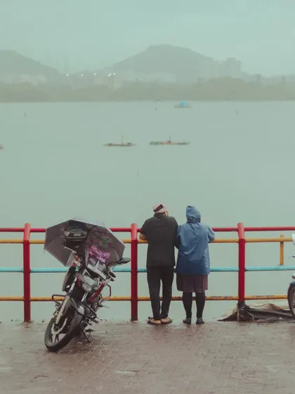 An older couple enjoys the monsoon magic at Powai Lake, proving that romance and quiet moments are timeless.