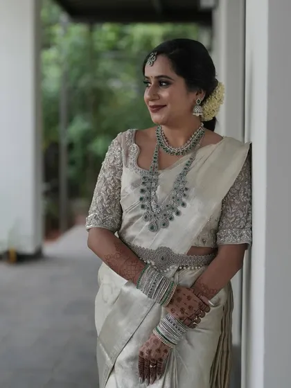A bride in a classic off-white silk saree, her look elevated by diamond jewelry.