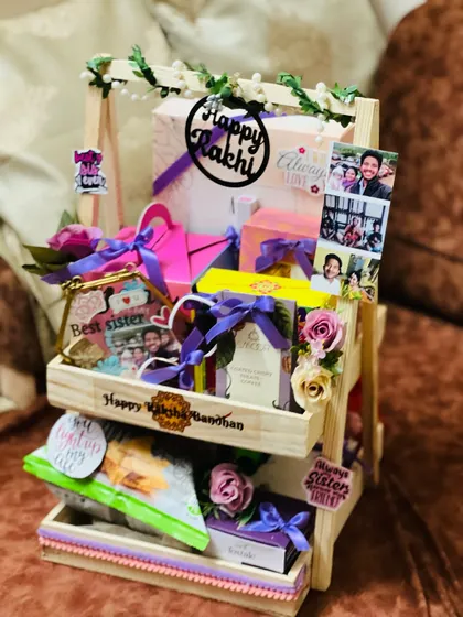 A side view of the personalized sister's Rakhi hamper, showing the arrangement of gifts and custom photos.