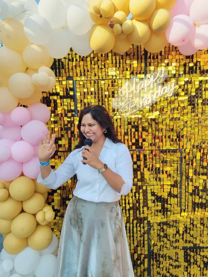 Waving to the guests at a sunny outdoor birthday party. A bright smile and a welcoming gesture are the first steps to creating a warm and inviting atmosphere.