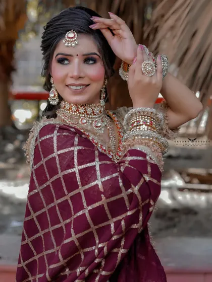 A graceful pose highlighting the bride's elegant hairstyle and the beautiful embroidery on her dupatta. Her smile makes the photo warm and engaging.
