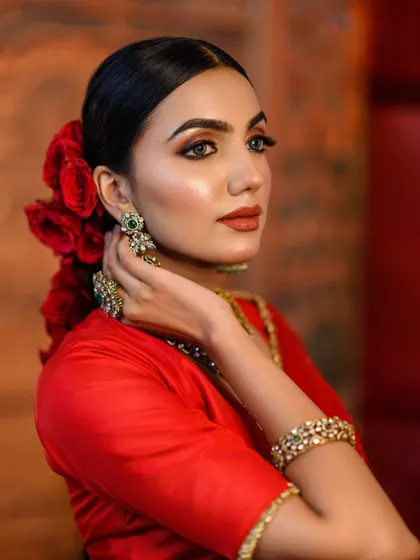 Another angle from our red-themed shoot, this portrait captures a moment of quiet grace. The lighting highlights the intricate jewellery and the model's serene expression.