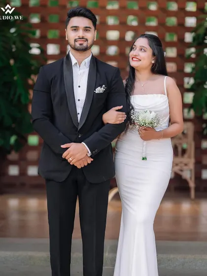 A perfect love story captured in a simple, elegant portrait. The groom in his sharp suit and the bride in her classic white dress embody timeless romance.