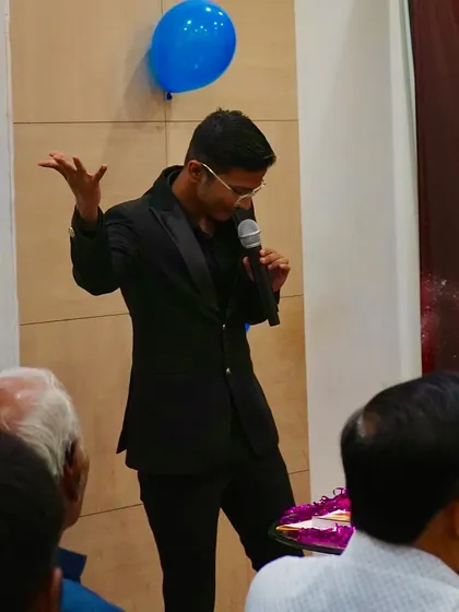 On stage at the Kusum Healthcare event, explaining the principles of psychological illusion to an engaged audience.