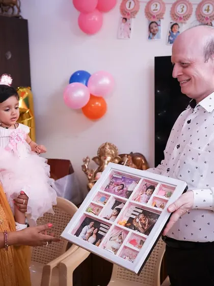 The little princess herself, looking curiously at the frame that holds all her first-year memories. A gift she will treasure as she grows.