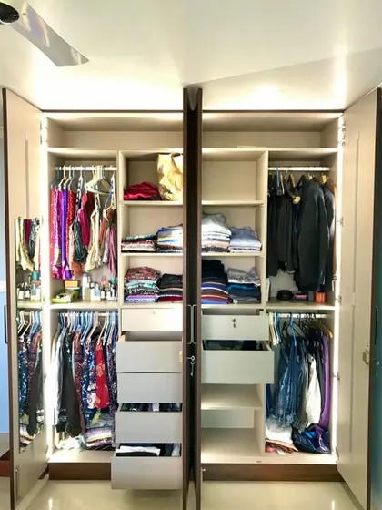 Our custom wardrobes are designed to fit your specific needs. This one features ample space for both hanging and folded clothes, with bright LED lighting to make finding items easy.