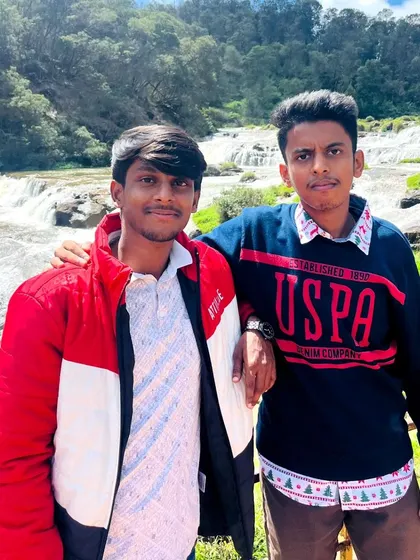 A duplicate of two friends posing in front of Pykara falls. Our trips are great for creating memories with your buddies.