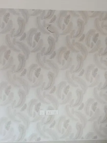 A light grey wallpaper with a soft, feathery pattern. This design is perfect for creating a serene and gentle atmosphere in a bedroom or living area.