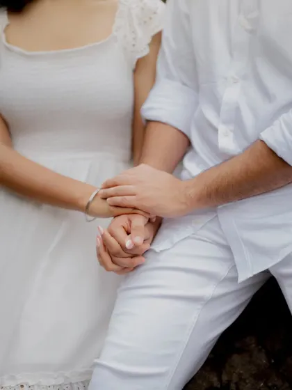 A detail shot focusing on the couple's intertwined hands, symbolizing their bond and commitment.