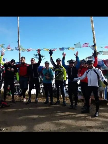 The team celebrating at a pass decorated with prayer flags in Bhutan. There's a great sense of shared achievement on our group tours.