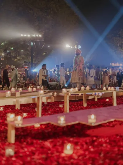 The groom's path to the mandap is lined with countless candles and a carpet of red rose petals. This is how I transform a simple walkway into a deeply romantic and symbolic journey.