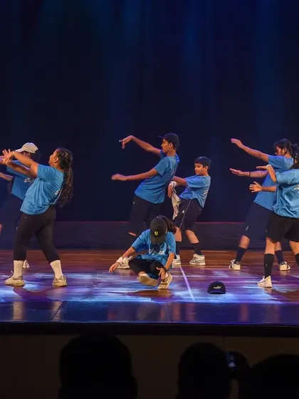 The dancers using the full width of the stage, creating dynamic lines and formations in their hip hop routine.