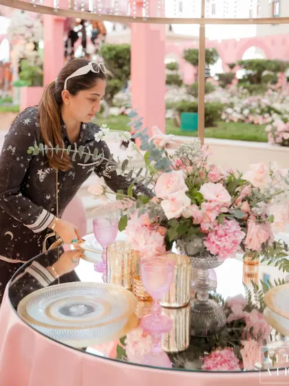 A behind-the-scenes shot of me styling a table at the 'Echoes of Pink' wedding in Doha. A wedding set is the calm after the storm of sleepless nights and intensive work.