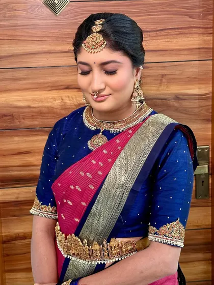 A beautiful portrait showing the details of the makeup and the intricate temple-style belt, part of a classic South Indian look.