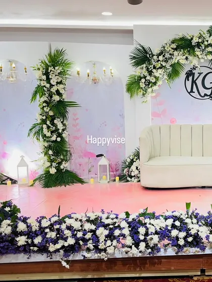 A sophisticated stage design with a white and green floral theme. I used a custom monogram, elegant arches, and lush palm leaves to create a fresh, tropical-inspired look for this event.
