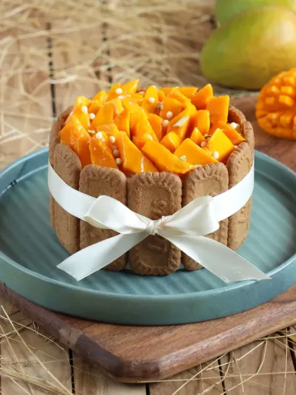 Our Mango Charlotte Cake is as beautiful as it is delicious. Lined with biscuits and filled with a light mango mousse, it's a stunning centerpiece for any table.