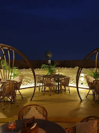 These private cabanas at Sesh Delhi offer an intimate dining experience under the stars. The domed structures, crafted from dark rattan, provide a sense of enclosure while remaining connected to the open rooftop atmosphere.
