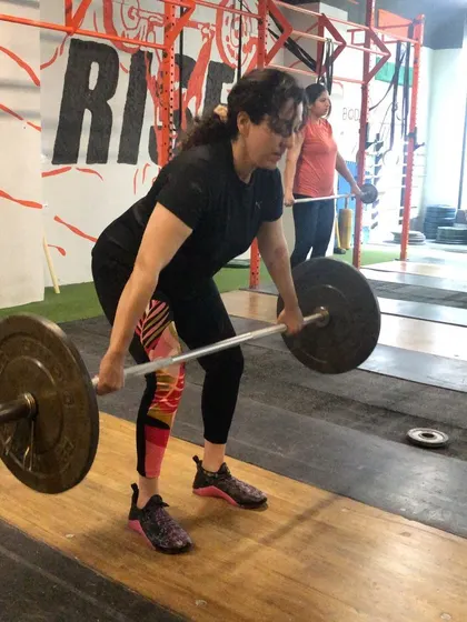A female athlete setting up for a snatch pull. Proper starting position is non negotiable, and we spend a lot of time ensuring the back is flat and the body is over the bar correctly.
