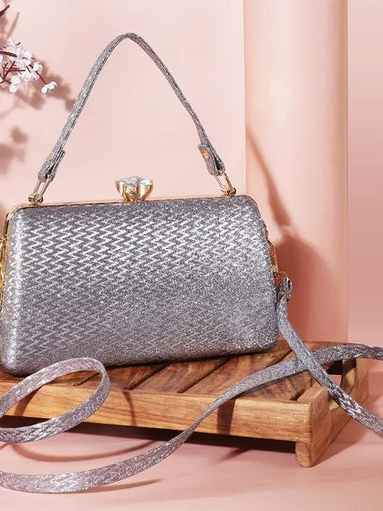 A classic and elegant shot of a silver glitter clutch. The soft pink background and vintage mirror create a feminine and sophisticated mood.