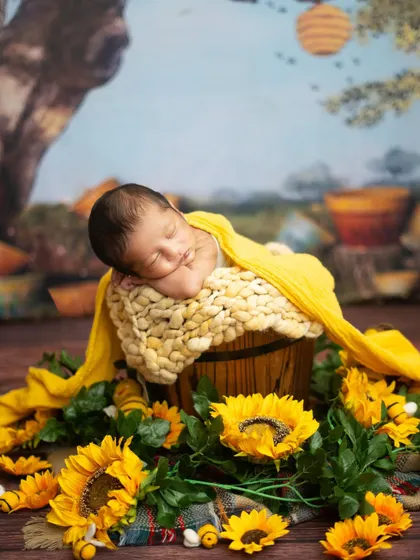A side profile of a newborn sleeping peacefully in a sunflower-themed setup. This angle highlights the sweet curve of their cheek and their tiny button nose.