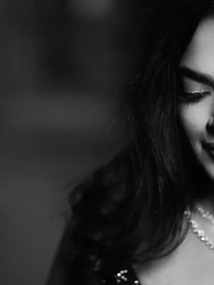 A timeless black and white portrait of the bride, her eyes closed in a moment of quiet contemplation. The shot beautifully highlights her delicate diamond necklace and elegant makeup.