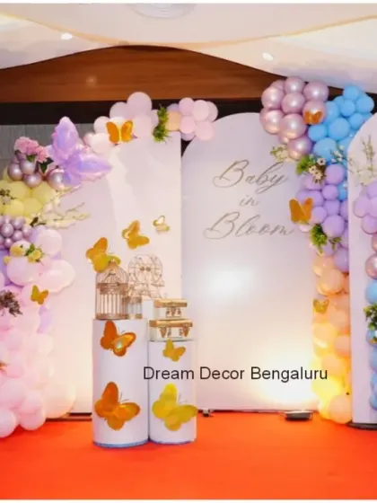 A 'Baby in Bloom' baby shower with a butterfly theme. The pastel balloon arrangements in pink, purple, and blue create a soft and dreamy atmosphere.