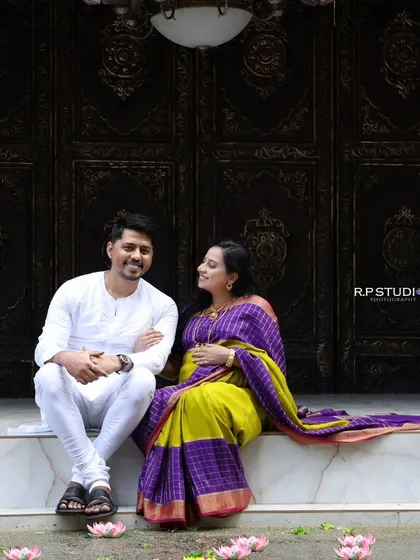 A candid moment captured at our outdoor-style setup. The couple sits on the steps of a traditional-looking entrance, sharing a quiet and happy moment.