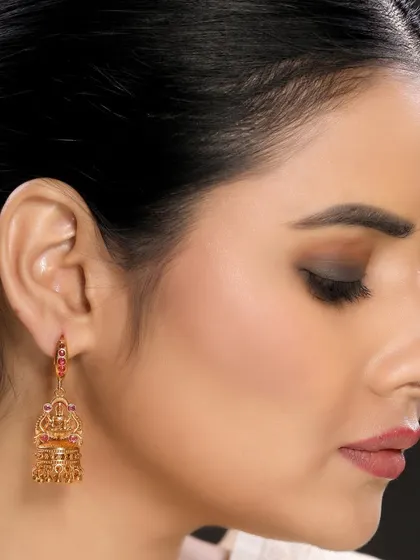 A detailed side view of a model wearing traditional jhumka earrings, perfect for highlighting specific earring designs.