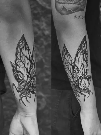 A tribute to a cinematic icon, Mothra. This black and grey tattoo focuses on the intricate, vein-like patterns of the wings, creating a piece that is both powerful and beautifully detailed.