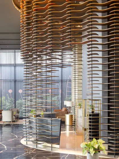 For the Godrej South Estate Experience Centre, we created a design that is an experience in itself. This semi-permeable, curved installation acts as a majestic curtain, balancing openness with intrigue. Crafted from layered MDF plates and illuminated by narrow-beam lights, it transforms a structural element into a piece of art, guiding visitors through a narrative of luxury.