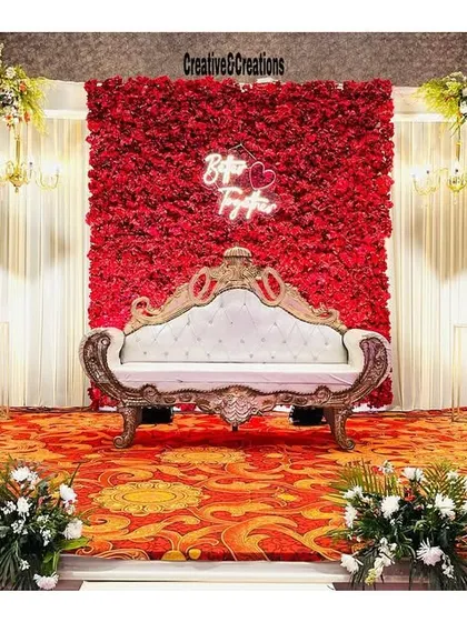 A full view of the elegant red and white reception stage. The design is symmetrical and balanced, creating a perfect backdrop for the main couple.