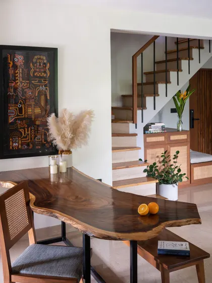A live-edge wooden dining table serves as the heart of our home, connecting the living and dining spaces with its organic shape.