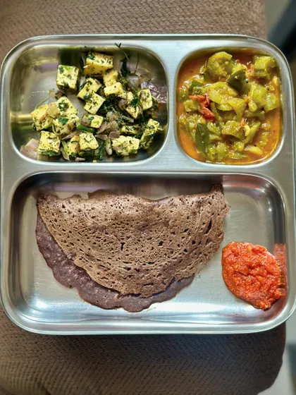 A delicious ragi dosa served with sautéed paneer, mixed vegetable curry, and tomato chutney.