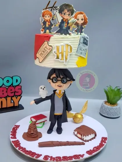 Wingardium Leviosa! A magical Harry Potter anti-gravity cake featuring a full fondant figurine of Harry holding up a floating tier, complete with iconic elements from the wizarding world.
