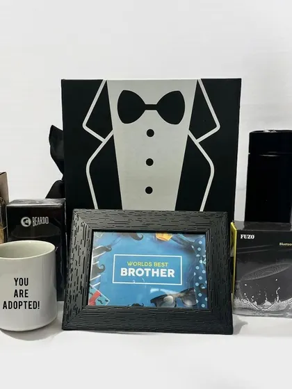 A fun and cheeky gift for a brother, this hamper includes a "World's Best Brother" photo frame alongside a mug that says "You are adopted!" It also contains chocolates, a speaker, and a tumbler.