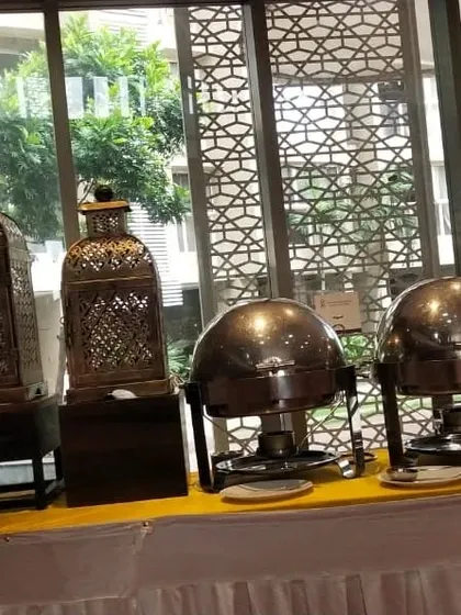 A buffet setup featuring traditional Indian style lanterns and domed chafing dishes. This theme is perfect for adding a classic, ethnic touch to your event.
