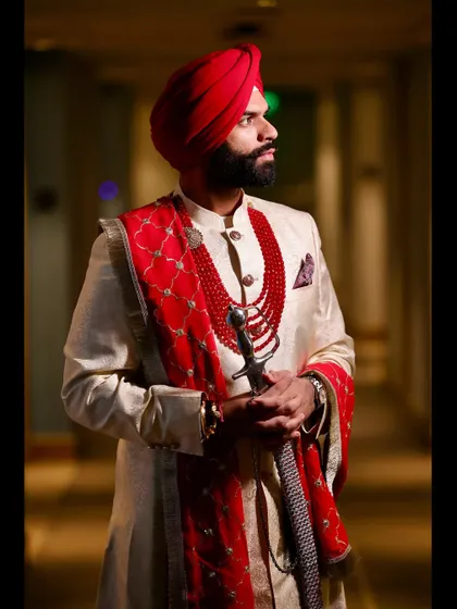 A striking portrait of a Sikh groom in his wedding attire, showcasing the rich colors and traditions. This demonstrates our expertise in capturing powerful solo portraits.