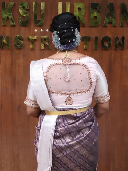 A back view of the mother's blouse from a family twinning set, showing the personalized 'SV' initials, just like the bride's.