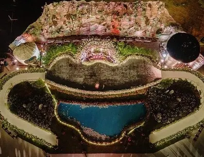An aerial shot capturing the full scale of the reception setup. You can see the intricate layout of the stage, the water body, and the entry and exit ramps, all designed and built by our team.