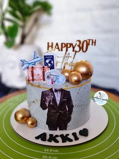 A stylish cake for a 30th birthday. This design combines a travel theme with a "man in a suit" topper, perfect for someone who loves adventure and style.
