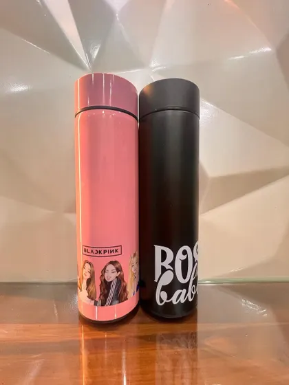 I offer a wide range of customization options for my bottles. Here you can see a pink bottle with a K-pop group design next to a black bottle with a "Boss Babe" quote, showing the versatility.