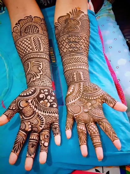 This is a classic Indian mehandi design with heavy, intricate patterns covering the entire hand and forearm. It includes paisleys, florals, and leaf motifs.