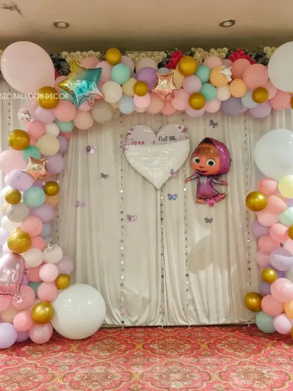 A pastel-colored balloon arch with a Masha foil balloon and a sequined heart accent for a sweet and charming party.