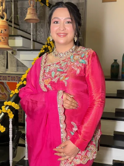 A full view of Ishita's elegant pink sharara set, complemented by a soft and dewy makeup look.