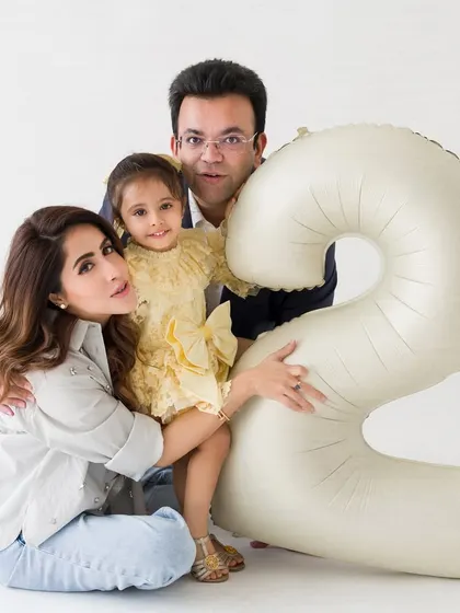 The whole family joins in to celebrate. This is a lovely family portrait capturing the love surrounding the little girl on her second birthday.