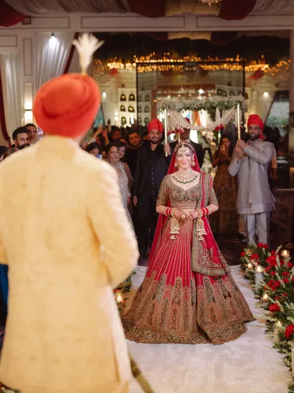 The bride's emotional and beautiful entrance, as she walks towards the groom who is waiting for her at the mandap. A truly timeless wedding moment.